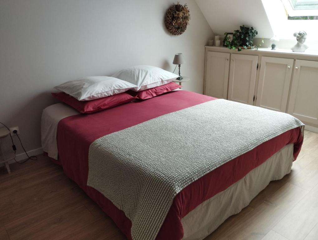 a bedroom with a bed with a red and white blanket at Le Clos des Mouettes in Calais