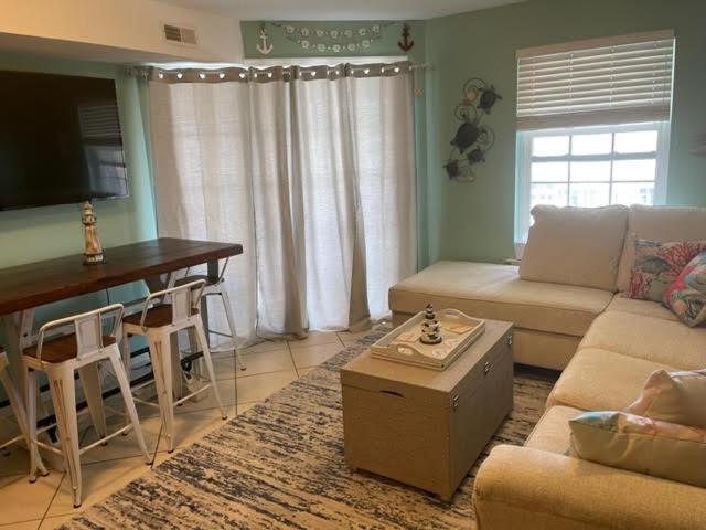 a living room with a couch and a table at Nw Condo Steps To Beach Overlooking Pool & Ocean in North Wildwood