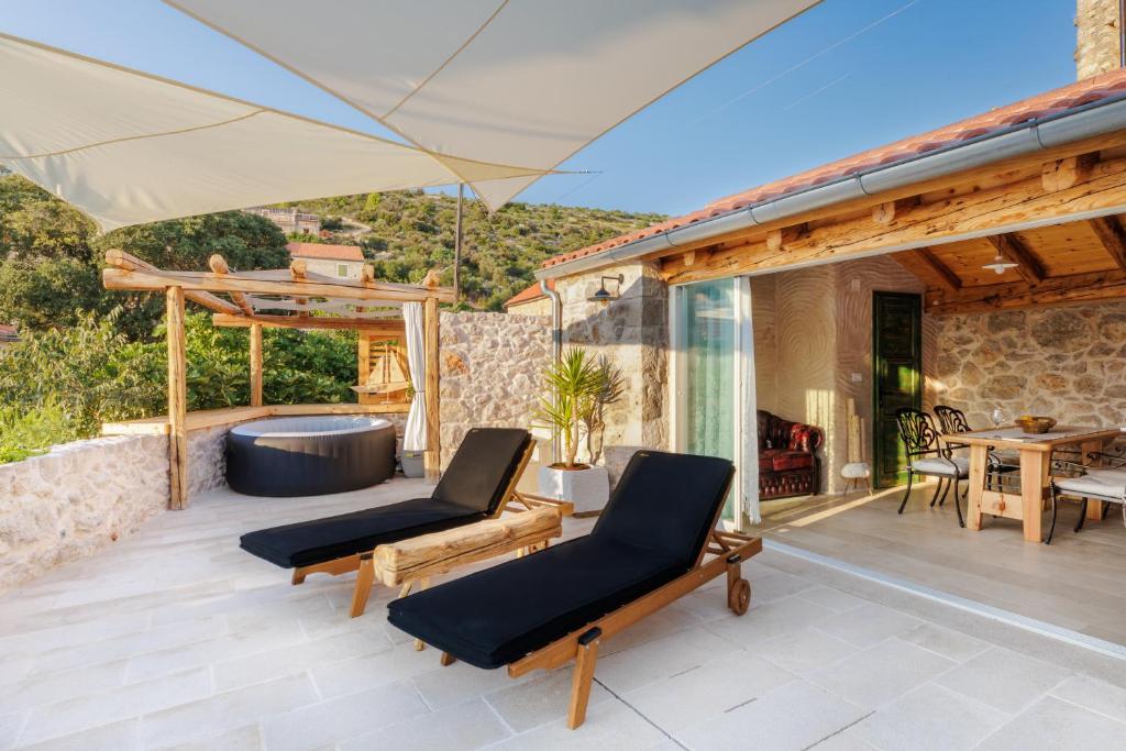 a patio with two chairs and a hot tub at Villa Teza Hvar in Hvar