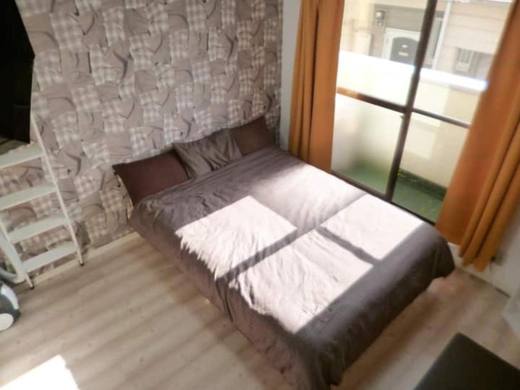 una cama sentada en una habitación junto a una ventana en The Mickey Carlton Ohashi Alpha Coat - Vacation STAY 15164 en Fukuoka