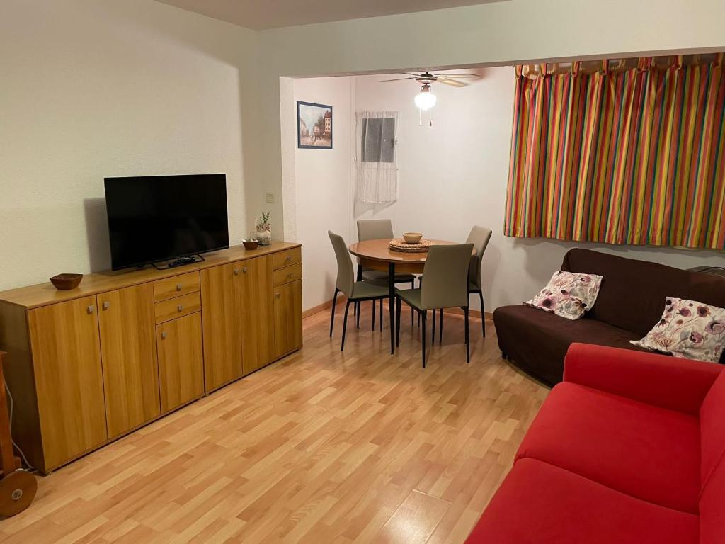 un salon avec un canapé et une table avec une télévision dans l'établissement Holiday Studio Calvi, à Calvi