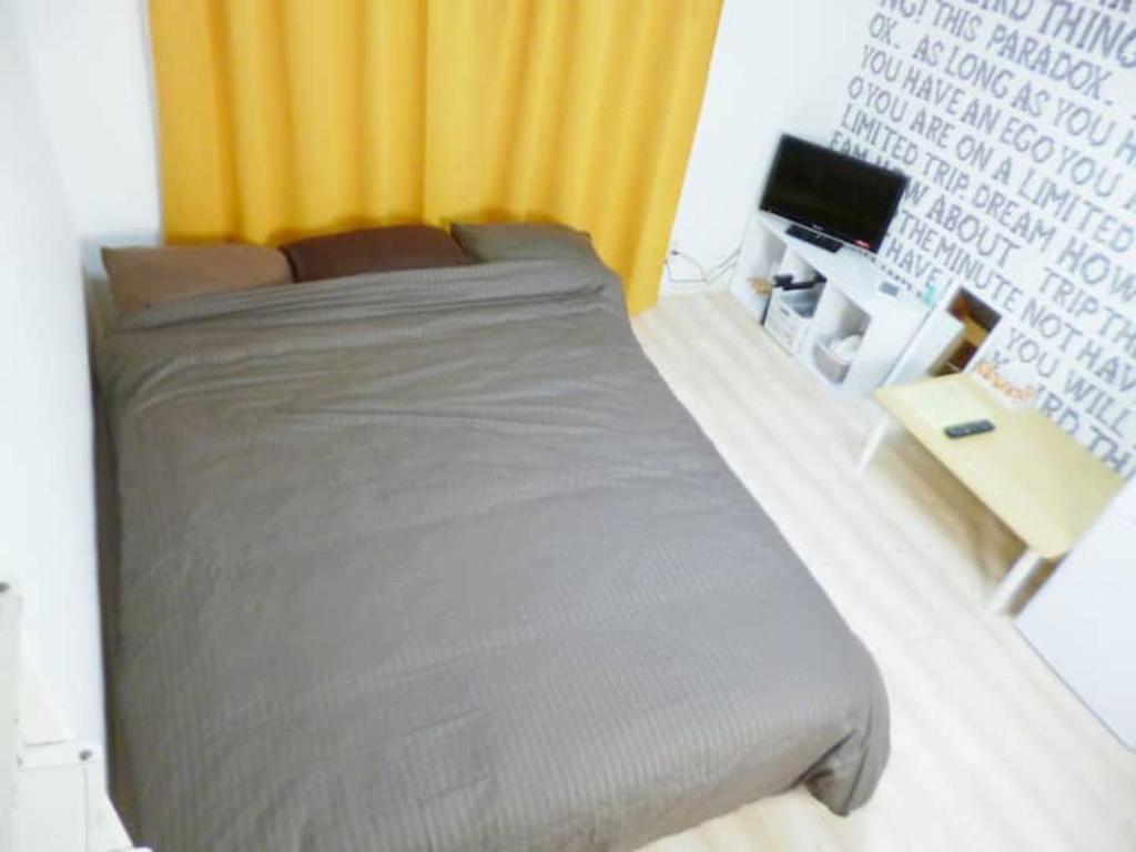 1 dormitorio con 1 cama grande y TV en The Mickey Carlton Ohashi Alpha Coat - Vacation STAY 15163 en Fukuoka