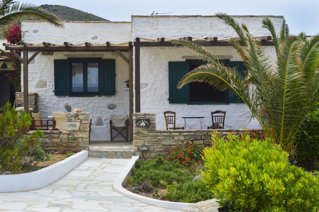a house with chairs in front of it at Villa Peristeri in Agios Georgios