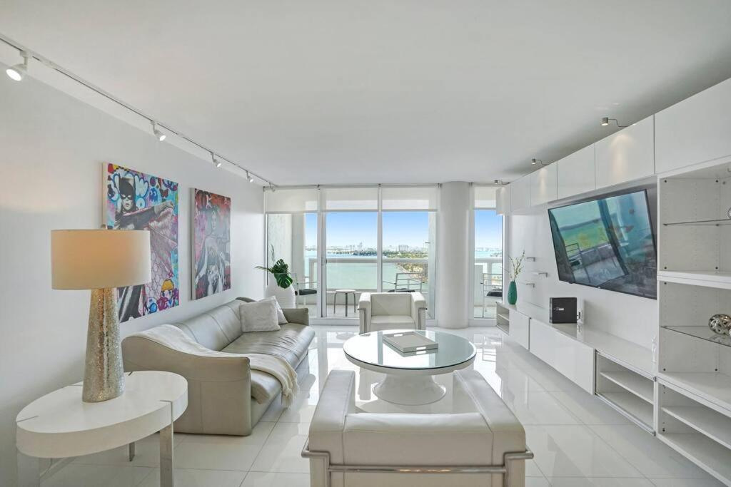 een woonkamer met een bank en een tv bij Seas The Day! Complete Panoramic Water Views in Miami