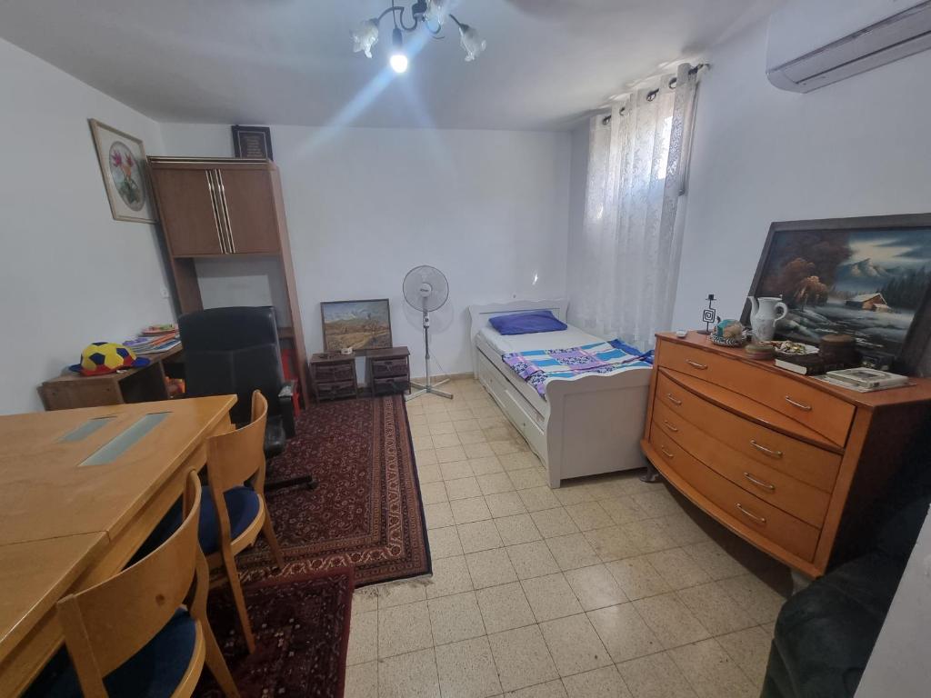 uma sala de aula com um quarto com uma cama e uma secretária em בית על חצי דונם במרכז קרית שמונה em Quriate-Chemoná