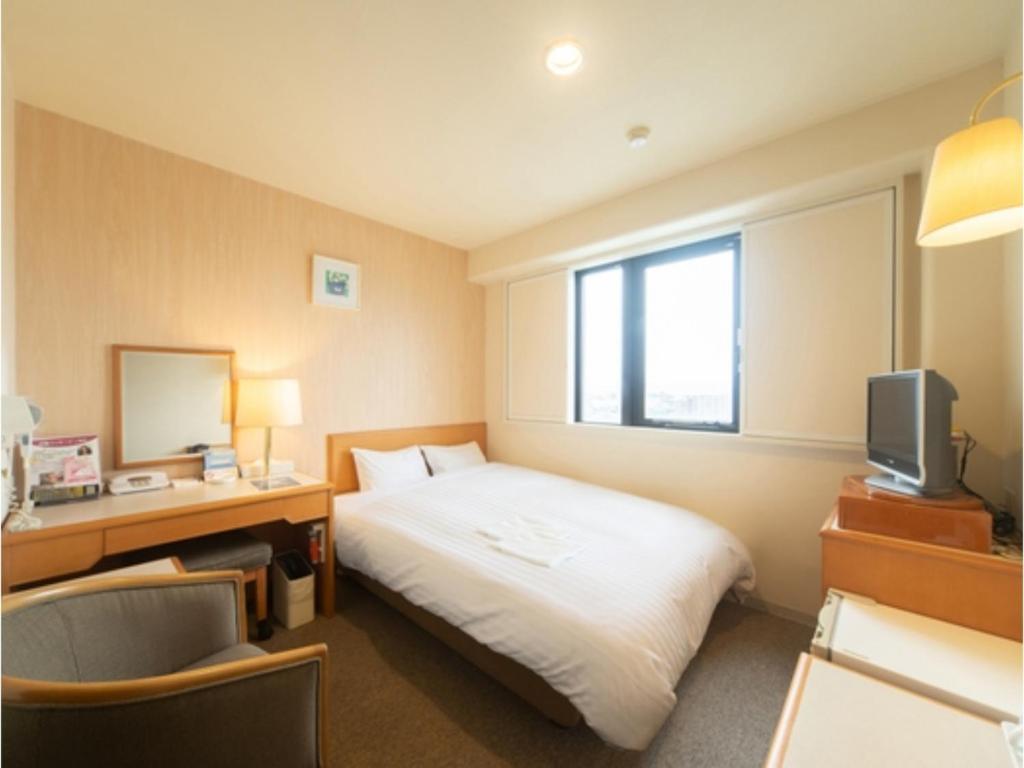 Habitación de hotel con cama, escritorio y TV. en Sun Hotel Tosu Saga - Vacation STAY 49482v en Tosu