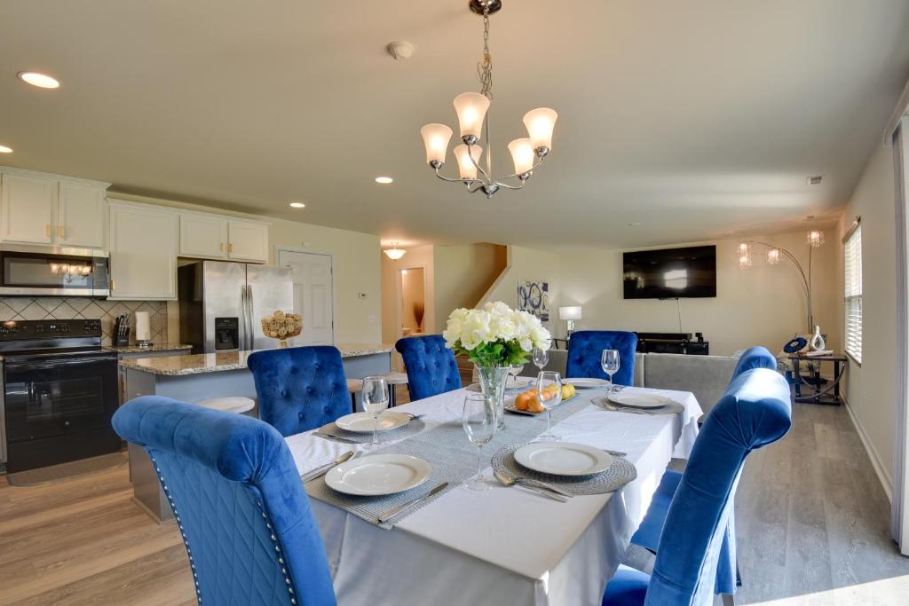 a dining room with a white table and blue chairs at Spacious Gastonia Home with Pool Access! in Gastonia
