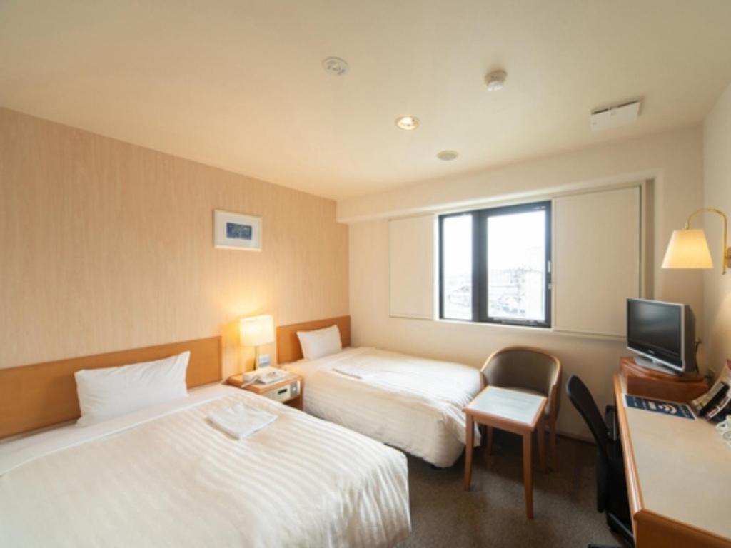 a hotel room with two beds and a television at Sun Hotel Tosu Saga - Vacation STAY 49480v in Tosu
