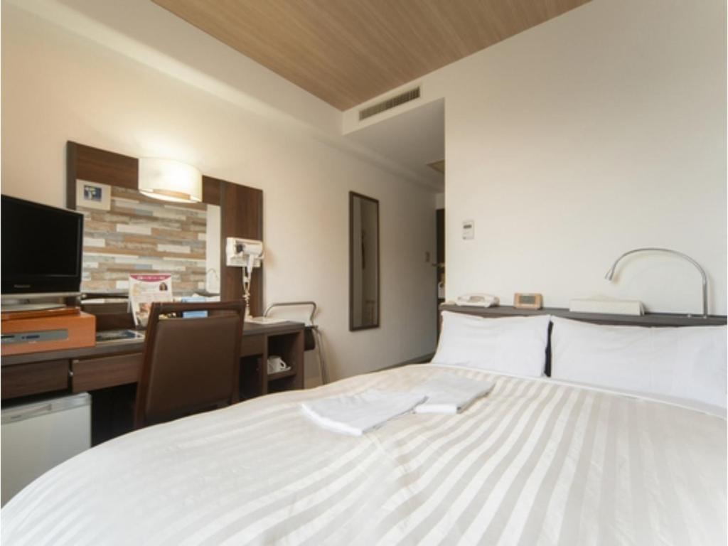 a large white bed in a room with a desk at Sun Hotel Tosu Saga - Vacation STAY 49470v in Tosu