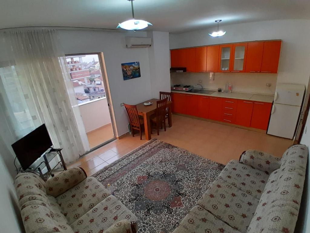 een woonkamer met een bank en een keuken bij Cozy apartment in the city center 2 in Shkodër