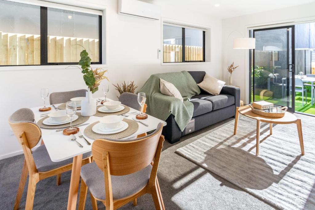 a living room with a table and chairs and a couch at Modern Townhouse Cashel Street 2 bed 2 bath in Christchurch