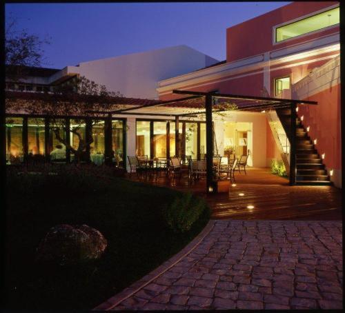 a house with a patio with tables and chairs at Hotel Acez in Vendas Novas