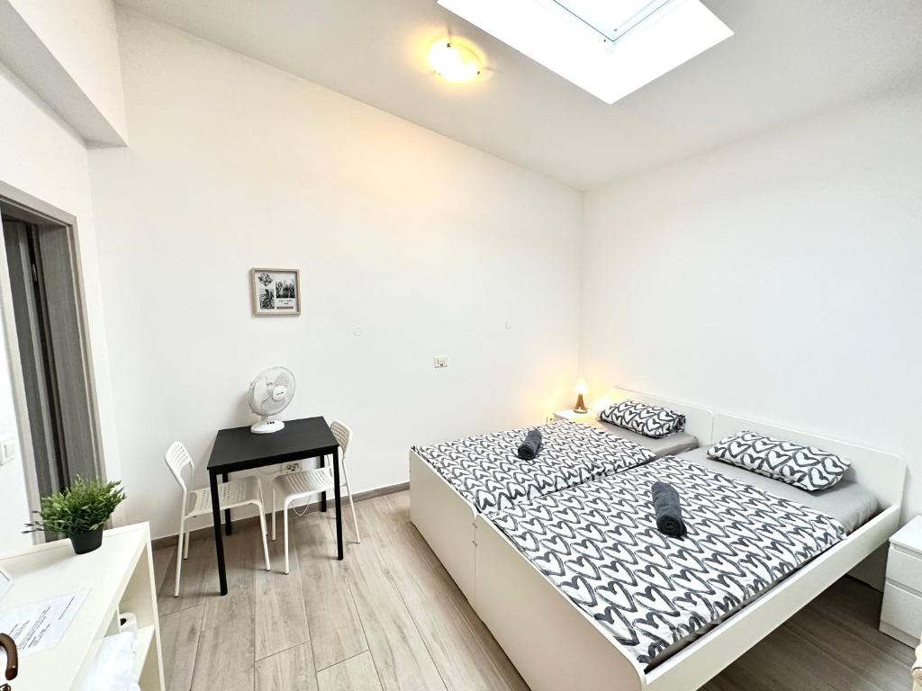 biała sypialnia z łóżkiem i biurkiem w obiekcie Center Station ROOMS w Lublanie