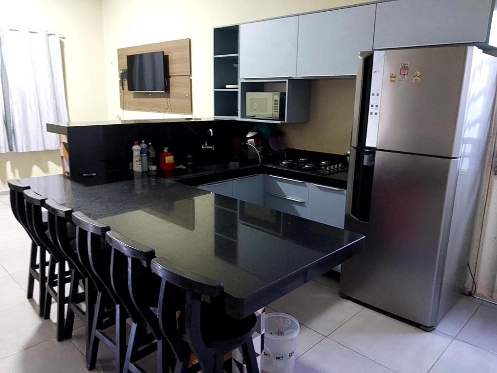 Casa Completa com 2 Quartos e Garagem في مارابا: مطبخ مع كونتر اسود توب وثلاجة