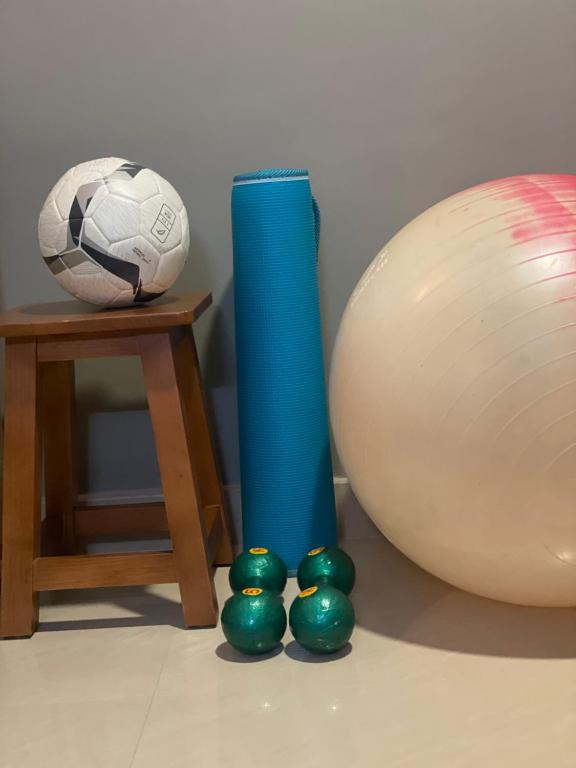 un pallone da calcio e tre palle verdi accanto a un vaso. di Calm and Cosy 1bhk in Thiruvananthapuram a Trivandrum