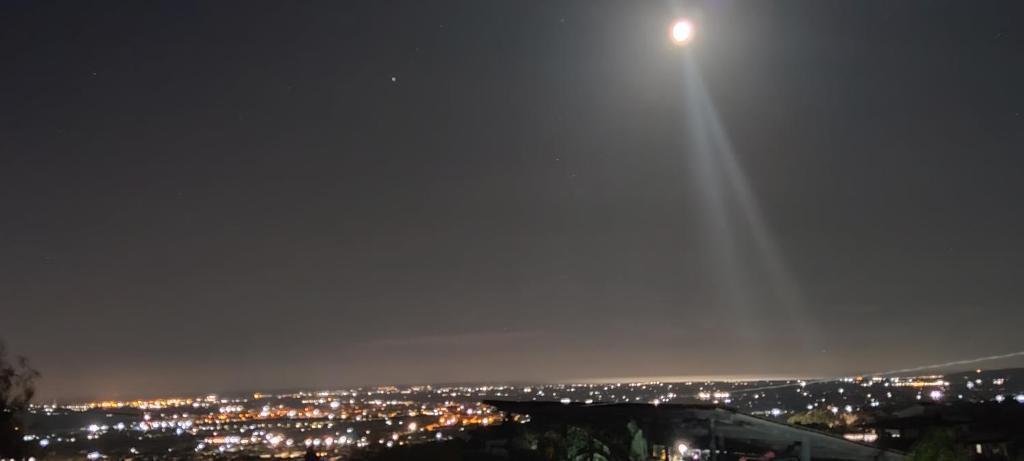 a view of a city at night with the moon at Country house with view on Syracusae gulf in Solarino