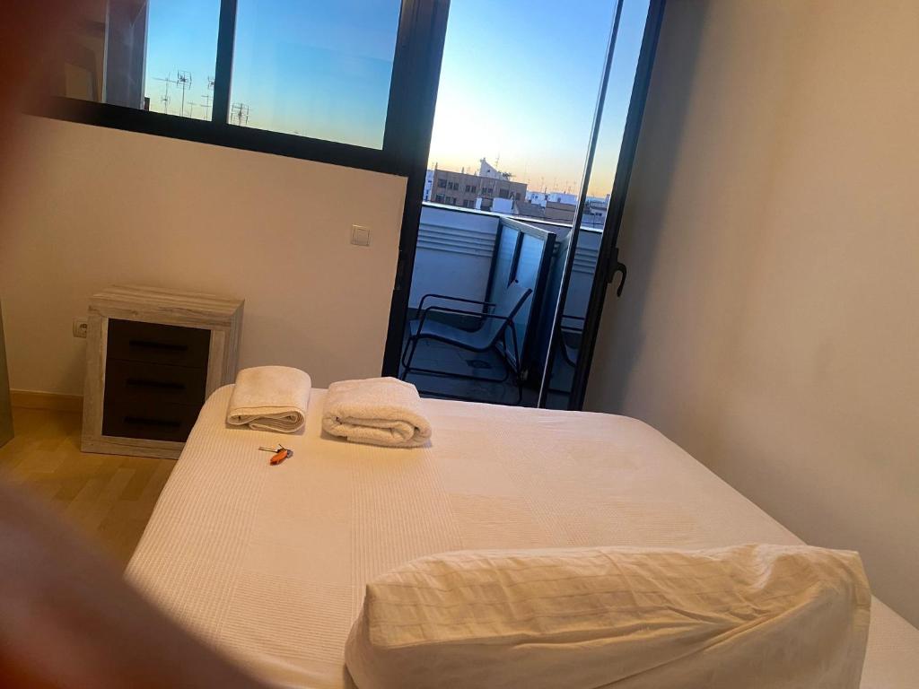 um quarto com uma cama com duas toalhas em Habitaciones confort em Benetúser