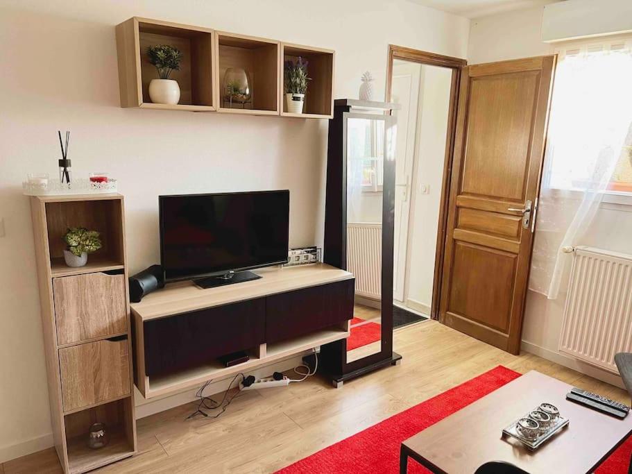 una sala de estar con TV de pantalla plana en un escritorio en Appartement Ensoleillé à 15 minutes de Paris en Vitry-sur-Seine
