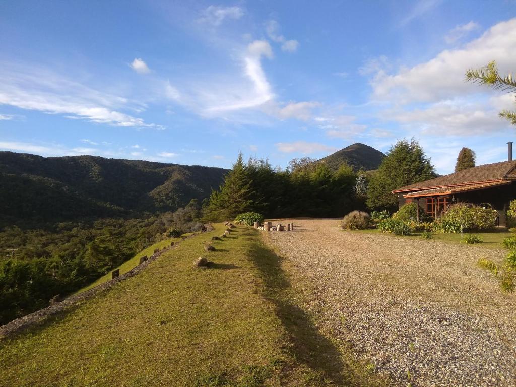 a group of people standing in a field next to a house at Campos da Bocaina in São José do Barreiro