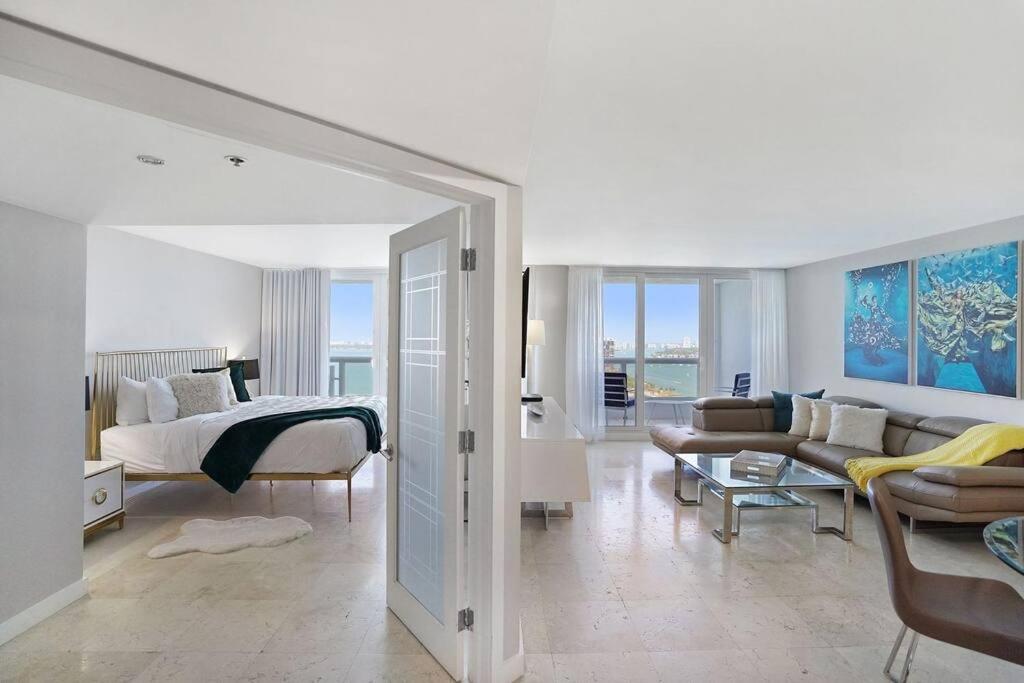 een woonkamer met een bed en een bank bij Good Morning Beautiful! Direct Water Views in Miami