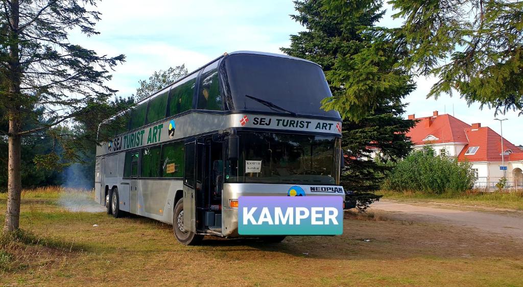 a double decker bus parked on the side of a road at Hotel Autokar Kamper 2 pietrowy, kuchnia, wc, kapsuly sypialne in Jastarnia