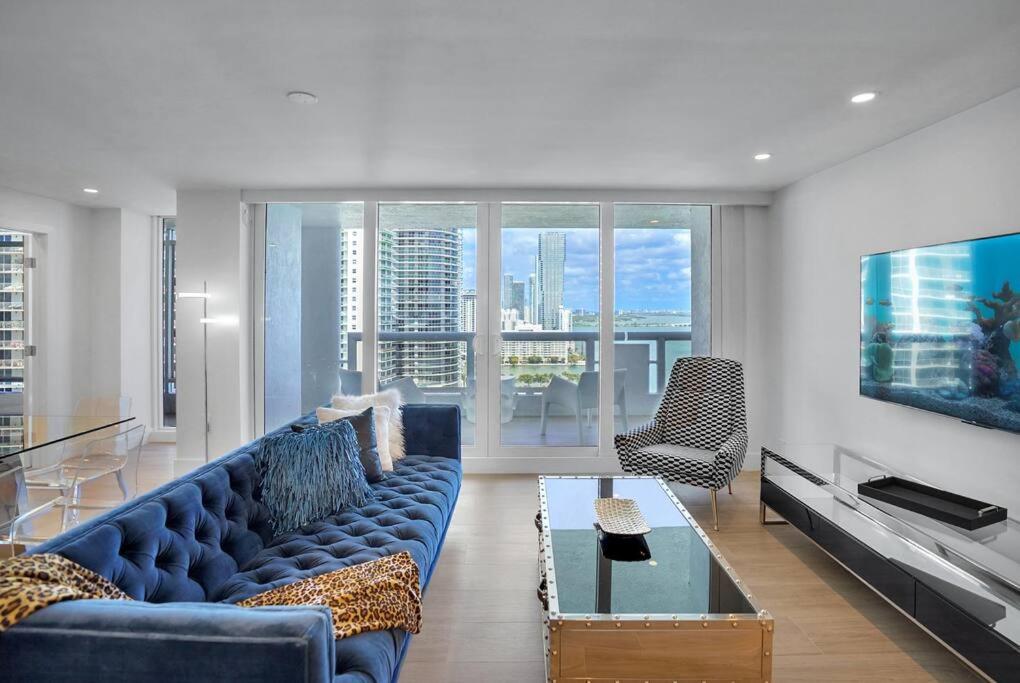 a living room with a blue couch and a tv at Make It Happen! Brand New with Amazing Water Views in Miami