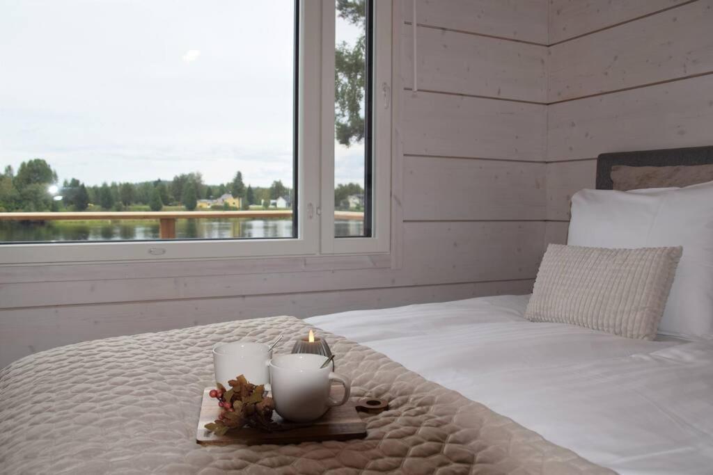 una camera da letto con un letto con una candela e una finestra di Villa Riverside a Rovaniemi
