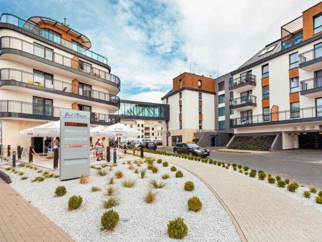 a building with a courtyard with plants in front of it at Bel Mare Resort ekskluzywny apartament dla wymagających klientów in Międzyzdroje