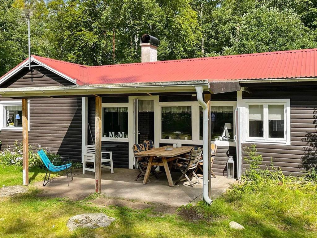 une maison avec une table de pique-nique et un toit rouge dans l'établissement 4 person holiday home in H STVEDA, à Lur