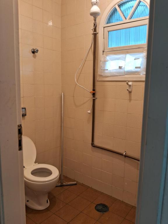 a bathroom with a toilet and a window at Loft Praia do Sonho in Itanhaém