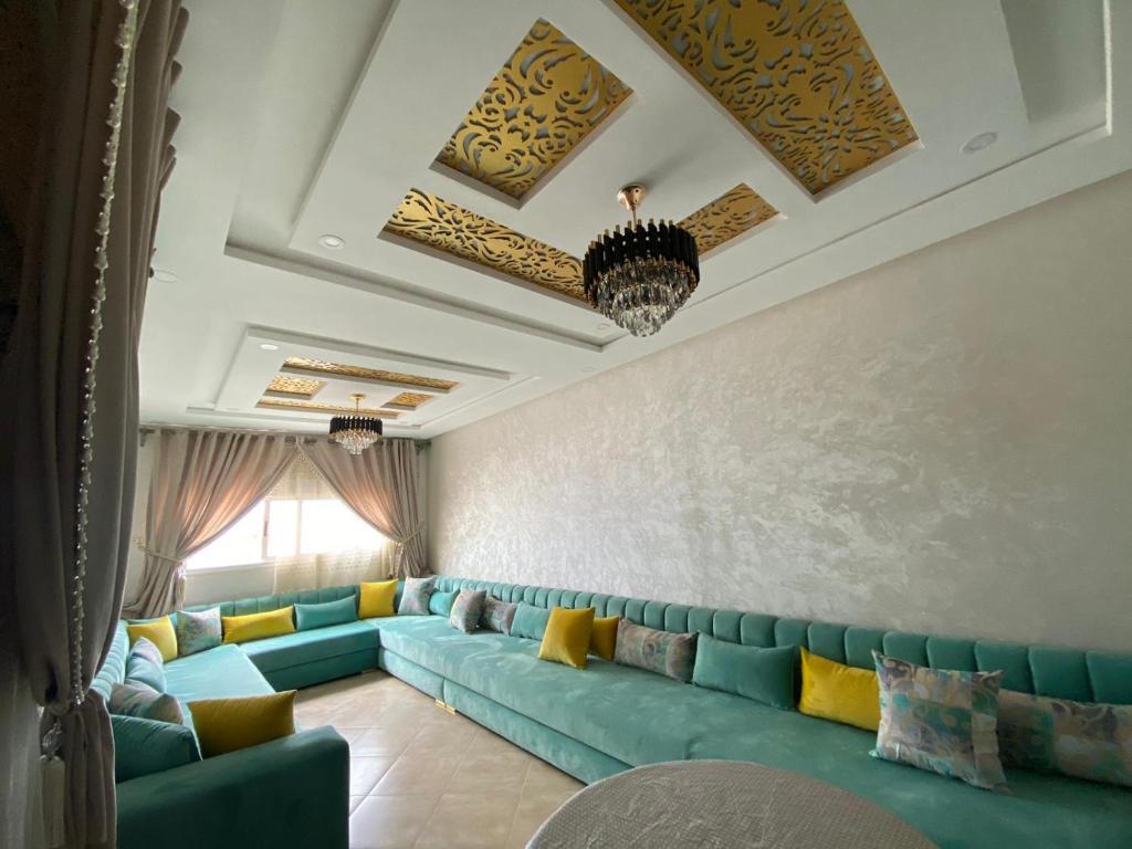 uma sala de estar com sofá azul e almofadas amarelas em La casa de Halima em Sidi Ifni