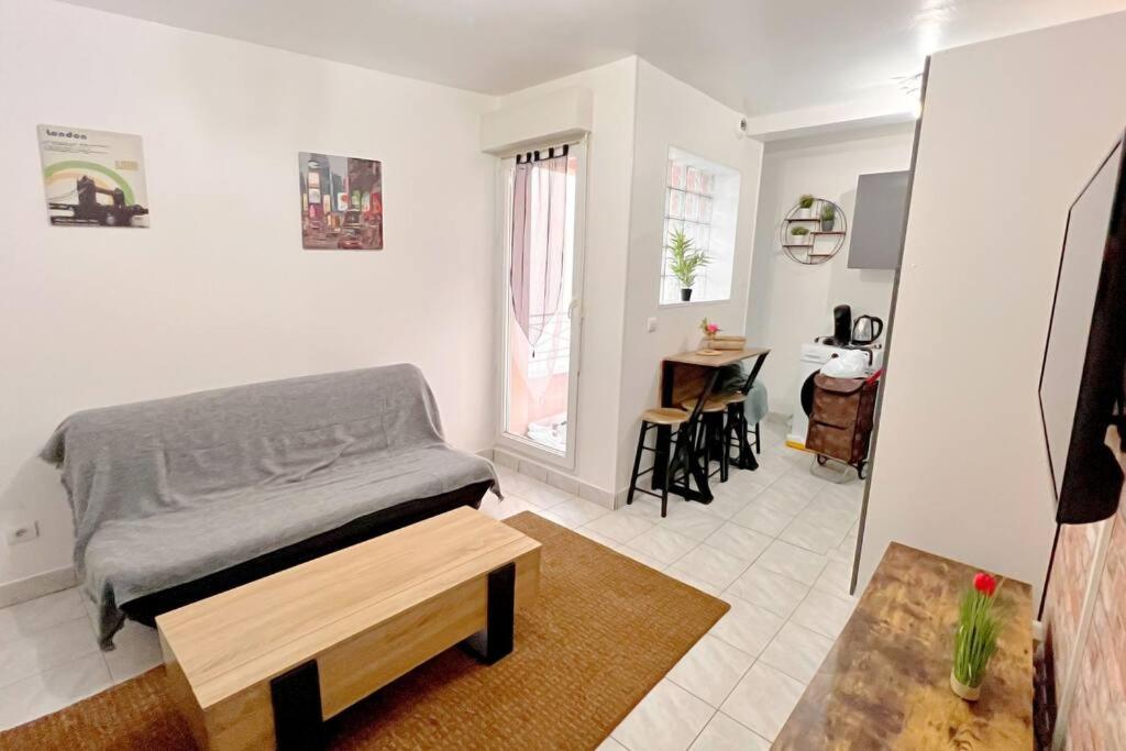 Un dormitorio con una cama y una mesa en una habitación. en Cosy Appart. aux portes de Paris, en Villejuif