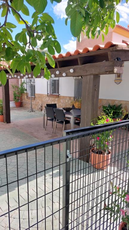 un patio con pergolato in legno, tavolo e sedie. di Cortijo El Algayubero a Puebla de Don Fadrique