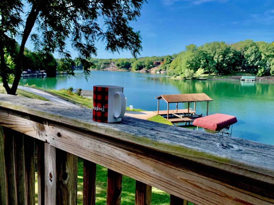 un riel de madera con una caja sobre un lago en Lake House with private beach 