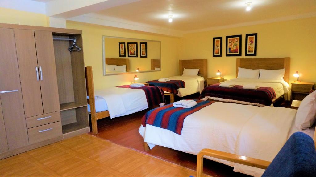 a hotel room with three beds in a room at Eco Aventura Cusco in Cusco