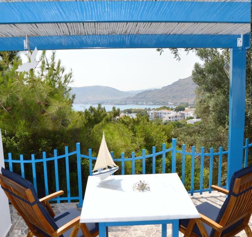 a table and chairs on a patio with a blue fence at Villa Bellina in Pefki Rhodes