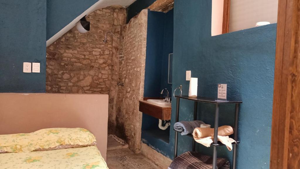 um quarto com um lavatório e uma parede azul em Casa Flores em Zacatecas