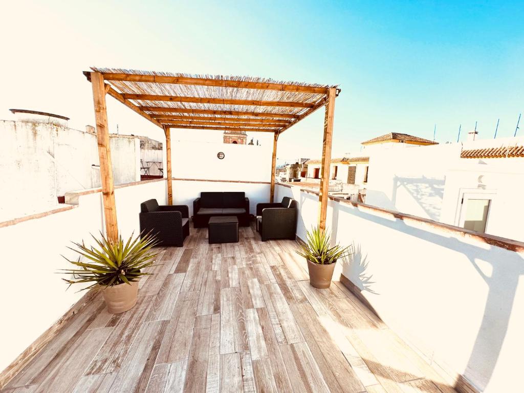 a rooftop deck with chairs and a pergola at DUPLEX IN TARIFA'S OLD TOWN in Tarifa