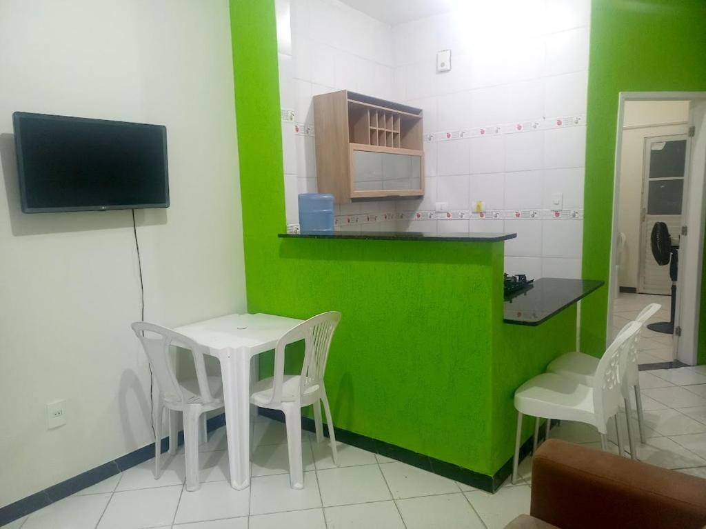a green and white kitchen with a table and chairs at Kitnet praia de Atalaia, Aracaju - Sergipe in Aracaju