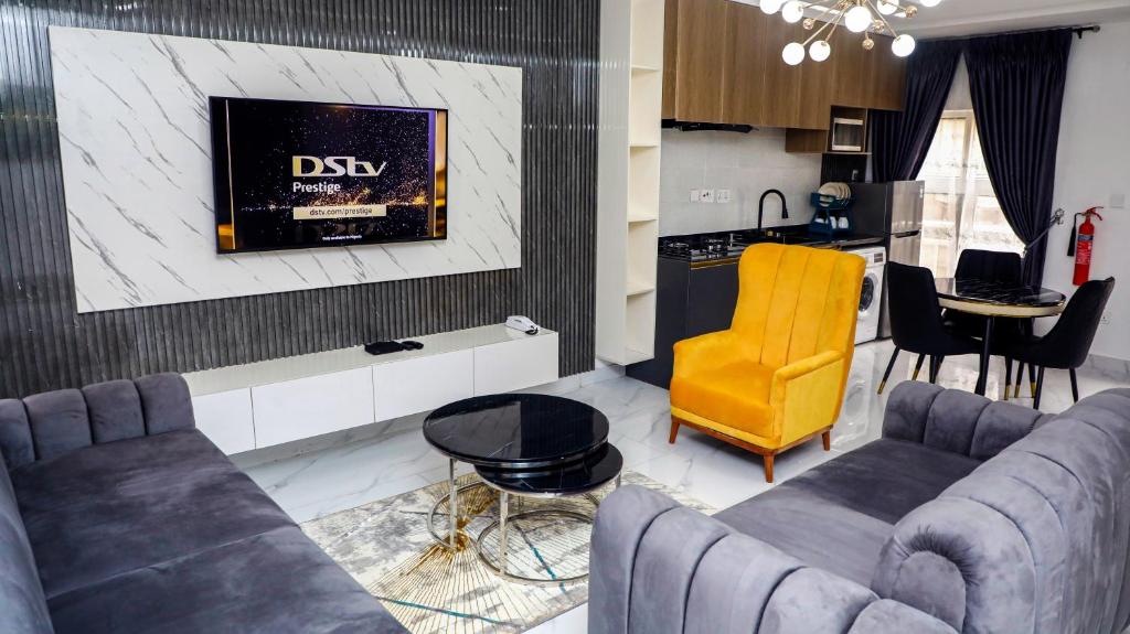a living room with two couches and a tv at Delight Apartments - Oniru VI in Lagos
