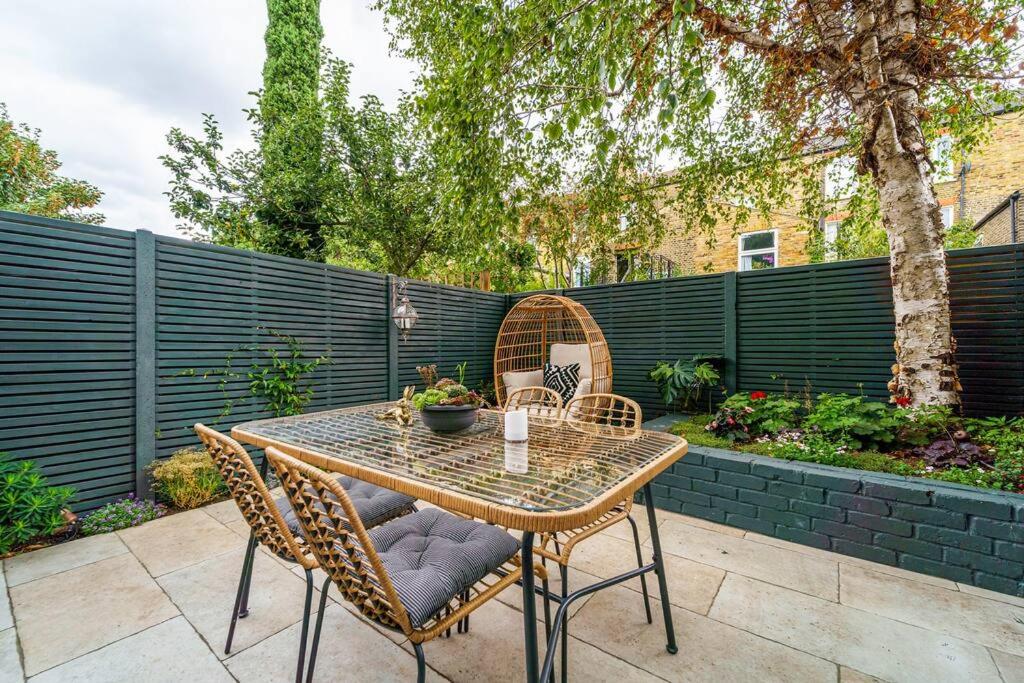 ロンドンにある2 Bedroom garden flatのパティオ(テーブル、椅子、フェンス付)