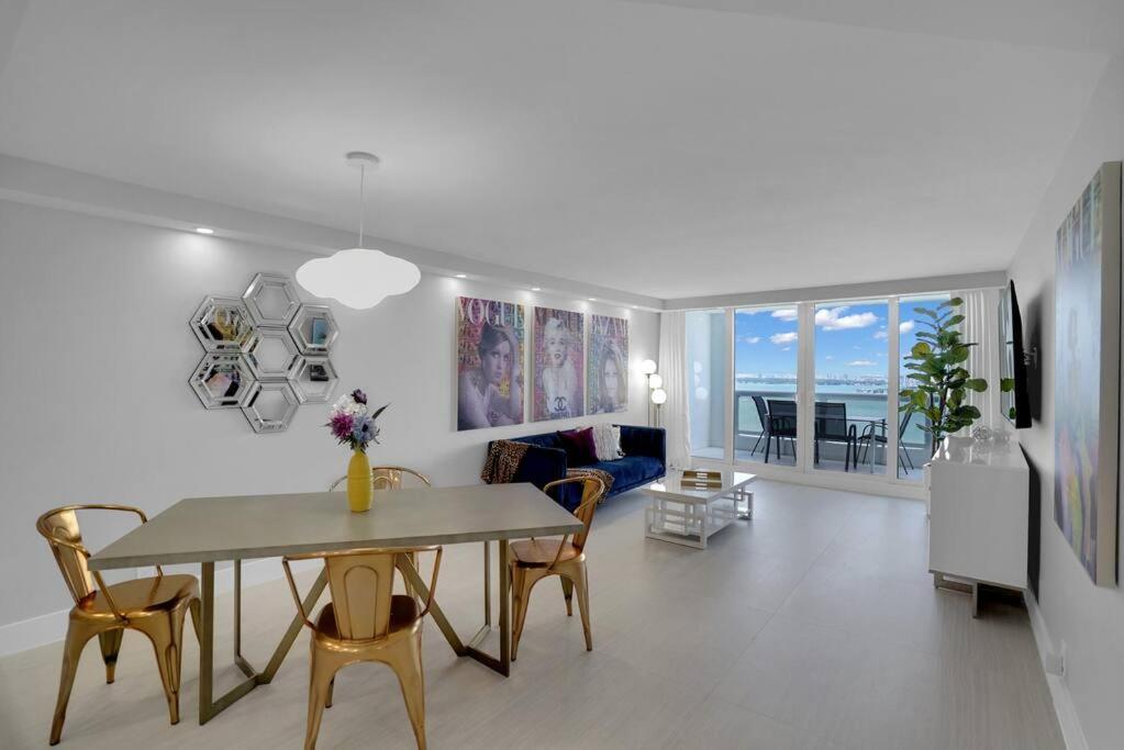 een eetkamer en een woonkamer met een tafel en stoelen bij Cloud Nine! Direct Water Views of Bay & Ocean! in Miami