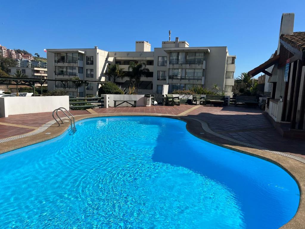 a large blue swimming pool on top of a building at Departamento Holiday Park Reñaca 306 Familiar in Viña del Mar