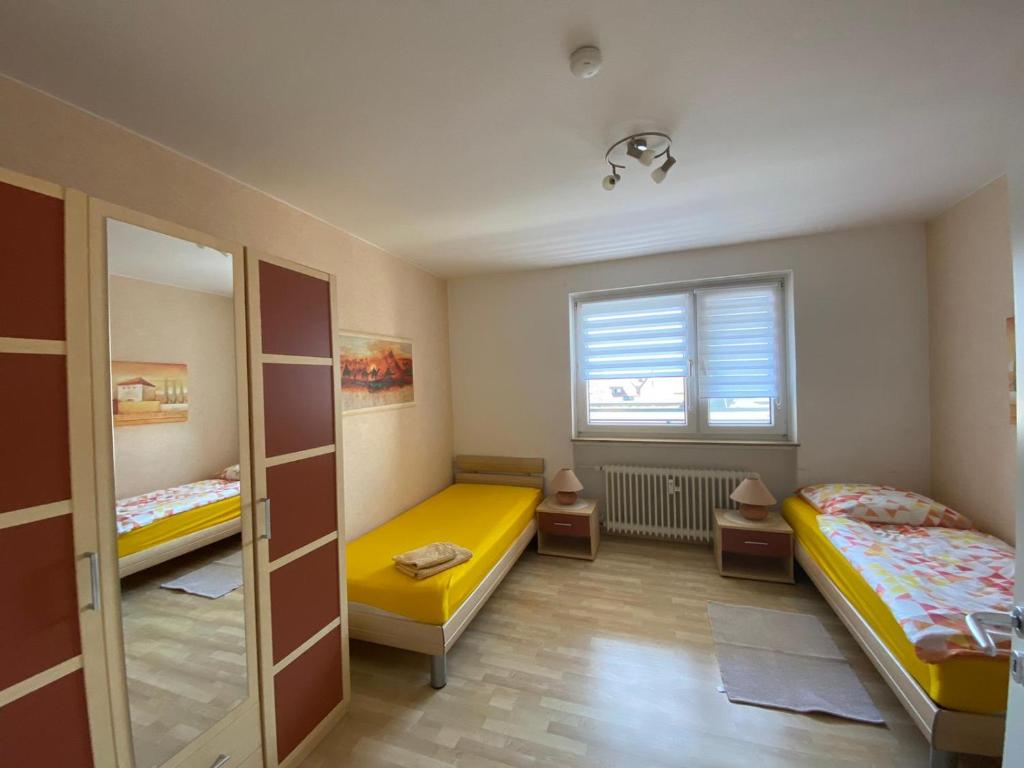 Cette petite chambre comprend 2 lits et une fenêtre. dans l'établissement Fewo Schöneck, à Schoneck