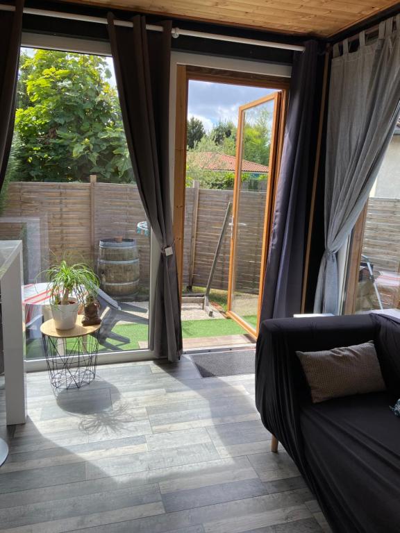 a room with sliding glass doors with a couch and a table at Gîte Lauraët in Linxe