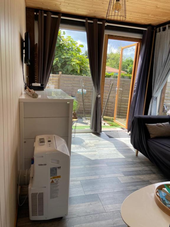 a room with a refrigerator and a room with a window at Gîte Lauraët in Linxe