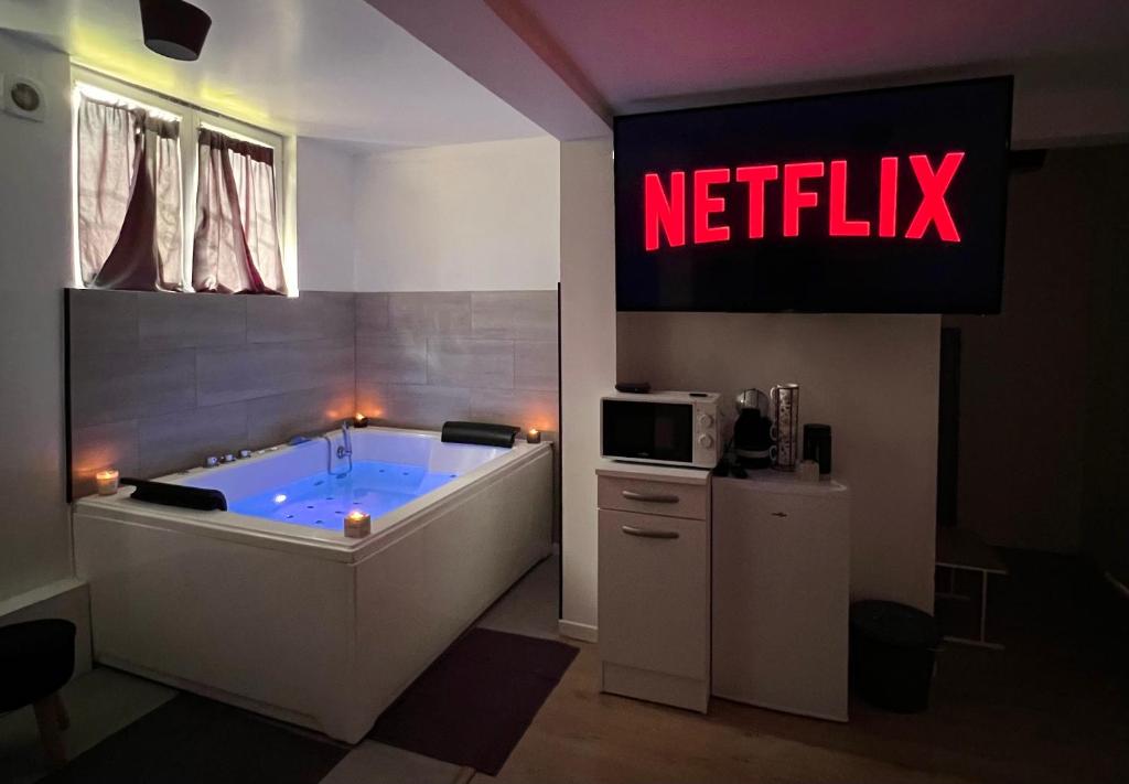 a bathroom with a tub with a netflix sign at Studio Cosy spa in Montmagny