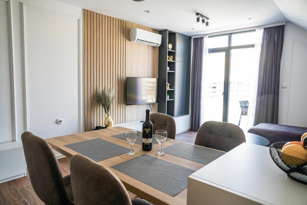 uma sala de jantar com uma mesa com copos de vinho em NOMAD Apartments em Niš