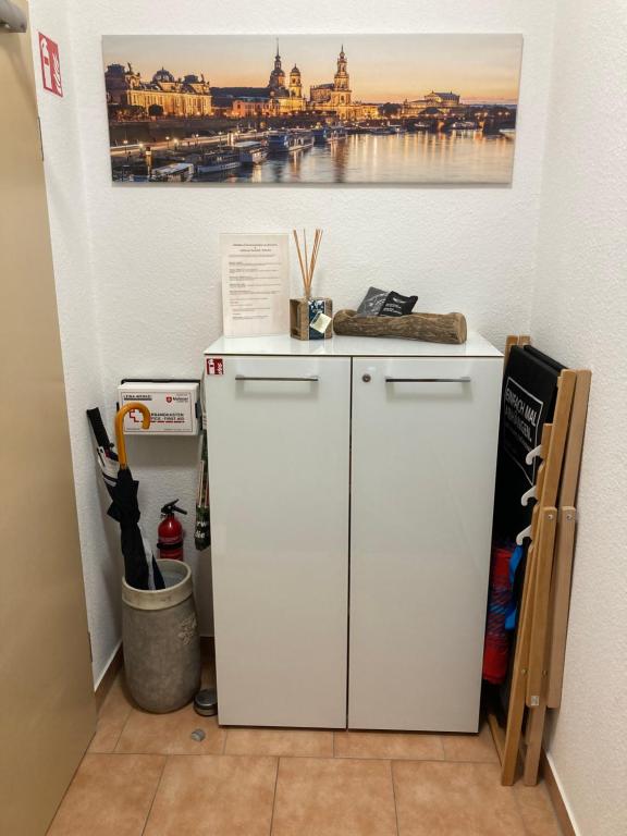 a white refrigerator in a room with a painting on the wall at Premium City Apartment Dresden in Dresden