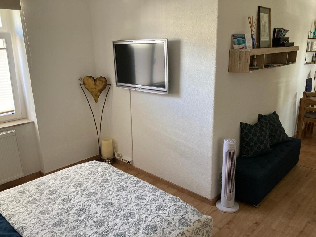 a bedroom with a bed and a tv on the wall at Premium City Apartment Dresden in Dresden